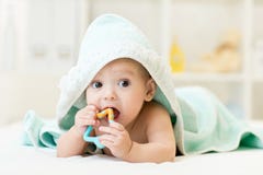 Dziecko z teether w usta pod kąpanie ręcznikiem przy pepinierą Obrazy Stock Dziecko z teether w usta pod kąpanie ręcznikiem przy pepinierą Obrazy Stock