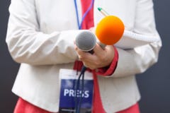 Dziennikarz przy konferencją prasową, pisać notatce, trzyma mikrofon zdjęcia stock Dziennikarz przy konferencją prasową, pisać notatce, trzyma mikrofon zdjęcia stock
