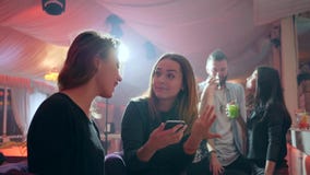 Dziewczyn spojrzenia przy ekranem laught na tle lumiere za barem odpierającym i telefon komórkowy w klubie zbiory Dziewczyn spojrzenia przy ekranem laught na tle lumiere za barem odpierającym i telefon komórkowy w klubie zbiory