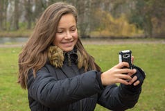 Dziewczyna bierze obrazki z jej telefonem komórkowym fotografia stock Dziewczyna bierze obrazki z jej telefonem komórkowym fotografia stock