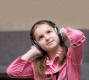 Dziewczyna nastolatek słucha muzyka z dużymi hełmofonami i przyglądającym up pensively Zdjęcie Stock Dziewczyna nastolatek słucha muzyka z dużymi hełmofonami i przyglądającym up pensively Zdjęcie Stock