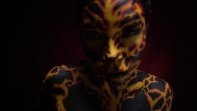 Dziewczyna z bodypainting na jej ciele w postaci powulkanicznej lawy rozwija się jej przyjaciel, zwolnione tempo zbiory Dziewczyna z bodypainting na jej ciele w postaci powulkanicznej lawy rozwija się jej przyjaciel, zwolnione tempo zbiory
