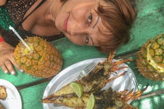 Dziewczyna z pina colada stołem z homarem i ananasem Poj?cie podr?? fotografia stock Dziewczyna z pina colada stołem z homarem i ananasem Poj?cie podr?? fotografia stock
