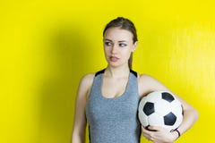 Dziewczyna z piłki nożnej piłką na żółtym tle obrazy royalty free Dziewczyna z piłki nożnej piłką na żółtym tle obrazy royalty free