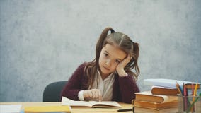 Dziewczynka czyta książkę siedzieć na szarym wnętrzu Uczennica studiuje podręcznika Dziecko mundurek szkolny jest zbiory wideo Dziewczynka czyta książkę siedzieć na szarym wnętrzu Uczennica studiuje podręcznika Dziecko mundurek szkolny jest zbiory wideo