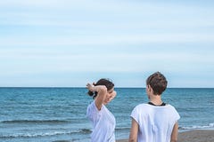Dziewczyny ono uśmiecha się na plaży i ciągnie ich włosy plecy z normalną postawą zdjęcia royalty free Dziewczyny ono uśmiecha się na plaży i ciągnie ich włosy plecy z normalną postawą zdjęcia royalty free