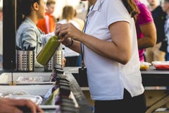 Dé la mujer que vende la botella de jugo fresco en tienda al aire libre en un día de verano fotografía de archivo Dé la mujer que vende la botella de jugo fresco en tienda al aire libre en un día de verano fotografía de archivo