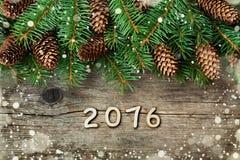 Décoration de Noël d'arbre de sapin et de cône de conifère sur le fond en bois texturisé, l'effet magique de neige et les nombres Photos libres de droits