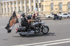 Dépassement des motards sur une moto avec un drapeau photographie stock libre de droits Dépassement des motards sur une moto avec un drapeau photographie stock libre de droits