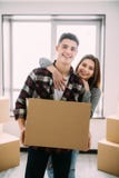 Déplacement à une nouvelle vie Couplez tenir des boîtes pour déplacer les mains et sourire à l'appareil-photo couples dans l'amou photos libres de droits Déplacement à une nouvelle vie Couplez tenir des boîtes pour déplacer les mains et sourire à l'appareil-photo couples dans l'amou photos libres de droits