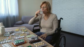 Désactivez la femelle dans les pilules potables de fauteuil roulant avec de l'eau, repêchage, maison de repos banque de vidéos Désactivez la femelle dans les pilules potables de fauteuil roulant avec de l'eau, repêchage, maison de repos banque de vidéos