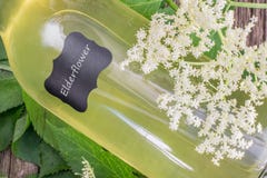 Détail d'une bouteille menteuse de sirop de fleur de sureau avec la fleur de sureau Images libres de droits Détail d'une bouteille menteuse de sirop de fleur de sureau avec la fleur de sureau Images libres de droits