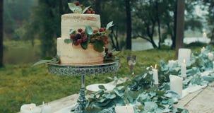 Dîner romantique servi à deux Composition en mariage : gâteau à deux niveaux avec des baies à la table décorée des bougies banque de vidéos Dîner romantique servi à deux Composition en mariage : gâteau à deux niveaux avec des baies à la table décorée des bougies banque de vidéos