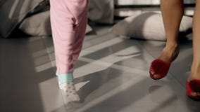 Dünne Beine der Frau und des Mädchens, die zu Hause auf sonnigen Boden gehen stock video footage Dünne Beine der Frau und des Mädchens, die zu Hause auf sonnigen Boden gehen stock video footage