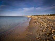 Długa, pusta i czysta piaska Stóg plaża w zmierzchu blisko Gdańskiego, Polska z dramatycznym niebieskim niebem obrazy stock Długa, pusta i czysta piaska Stóg plaża w zmierzchu blisko Gdańskiego, Polska z dramatycznym niebieskim niebem obrazy stock