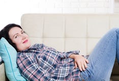 E Junge Brunettefrau, die zu Hause in einer Freizeit denkt stockbild E Junge Brunettefrau, die zu Hause in einer Freizeit denkt stockbild