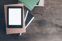 E-Leser auf Stapel Büchern auf hölzernem Schreibtisch lizenzfreie stockbilder E-Leser auf Stapel Büchern auf hölzernem Schreibtisch lizenzfreie stockbilder
