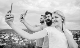 E Mujer bonita y hombres que sostienen smartphones en manos r fotografía de archivo E Mujer bonita y hombres que sostienen smartphones en manos r fotografía de archivo