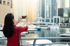 Turist- ta ett foto av den Dubai marina med den smarta telefonen royaltyfria foton Turist- ta ett foto av den Dubai marina med den smarta telefonen royaltyfria foton