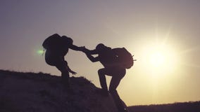 E Η ομάδα τουριστών δανείζει ένα χέρι βοηθείας αναρριχείται στον τρόπο ζωής οι απότομοι βράχοι φιλμ μικρού μήκους E Η ομάδα τουριστών δανείζει ένα χέρι βοηθείας αναρριχείται στον τρόπο ζωής οι απότομοι βράχοι φιλμ μικρού μήκους