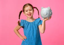 E κορίτσι παιδιών με τη piggy τράπεζα σε ένα χρωματισμένο ρόδινο υπόβαθρο στοκ φωτογραφία με δικαίωμα ελεύθερης χρήσης E κορίτσι παιδιών με τη piggy τράπεζα σε ένα χρωματισμένο ρόδινο υπόβαθρο στοκ φωτογραφία με δικαίωμα ελεύθερης χρήσης