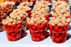 Eanuts Caramelised com as sementes de sésamo em uns copos transparentes vermelhos fotos de stock Eanuts Caramelised com as sementes de sésamo em uns copos transparentes vermelhos fotos de stock