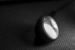 Earbud noir sur le fond noir photo stock Earbud noir sur le fond noir photo stock