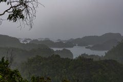 East Misool, group of small island in shallow blue lagoon water under the rain