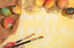 Easter colorful eggs with two painter's brushes,jute canvas,arranged on yellow painted watercolor paper. royalty free stock photography Easter colorful eggs with two painter's brushes,jute canvas,arranged on yellow painted watercolor paper. royalty free stock photography