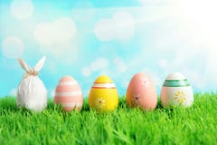 Easter egg wrapped in a paper in the shape of a bunny with colorful Easter eggs on green grass. Spring holidays concept stock image Easter egg wrapped in a paper in the shape of a bunny with colorful Easter eggs on green grass. Spring holidays concept stock image