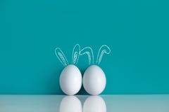 Easter eggs painted with rabbits ears on the blue background