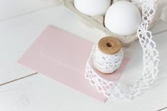 Easter eggs on wooden background with pink envelope