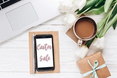 Easter sale on empty phone screen and laptop with morning coffee royalty free stock photography Easter sale on empty phone screen and laptop with morning coffee royalty free stock photography