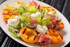 Easy Dietary Salad With Mozzarella, Prosciutto, Grilled Apricots, Red Onion And Lettuce Close-up On A Plate. Horizontal Royalty Free Stock Image Easy Dietary Salad With Mozzarella, Prosciutto, Grilled Apricots, Red Onion And Lettuce Close-up On A Plate. Horizontal Royalty Free Stock Image