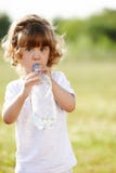 Eau propre potable de petite fille de bouteille Image libre de droits Eau propre potable de petite fille de bouteille Image libre de droits