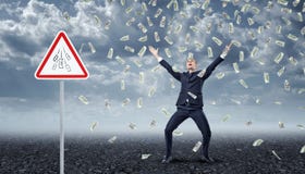 Ecstatic businessman standing under many dollar bills falling from the sky with a traffic warning sign `Money` nearby. Royalty Free Stock Photography Ecstatic businessman standing under many dollar bills falling from the sky with a traffic warning sign `Money` nearby. Royalty Free Stock Photography