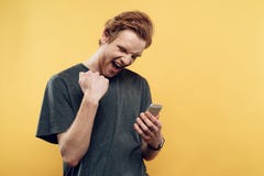 Ecstatic Guy Celebrating Success Using Smartphone royalty free stock photography Ecstatic Guy Celebrating Success Using Smartphone royalty free stock photography