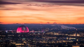 Edificio de la arena del globo iluminado en rosa contra el cielo de la puesta del sol durante vacaciones de la Navidad fotografía de archivo Edificio de la arena del globo iluminado en rosa contra el cielo de la puesta del sol durante vacaciones de la Navidad fotografía de archivo