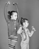 Educaci?n sana Beb?s deportivos Despu?s de su hermana Ni?o lindo de las muchachas que ejercita con pesas de gimnasia Motivaci?n y fotografía de archivo Educaci?n sana Beb?s deportivos Despu?s de su hermana Ni?o lindo de las muchachas que ejercita con pesas de gimnasia Motivaci?n y fotografía de archivo