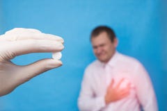 Een arts in een medische handschoen die een pil voor ziekten van het cardiovasculaire systeem, een mannelijke patiënt houden die stock foto Een arts in een medische handschoen die een pil voor ziekten van het cardiovasculaire systeem, een mannelijke patiënt houden die stock foto