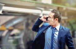 Een Aziatische zakenman spreekt aan zijn smartphone in een gedrang en een bus royalty-vrije stock afbeelding Een Aziatische zakenman spreekt aan zijn smartphone in een gedrang en een bus royalty-vrije stock afbeelding