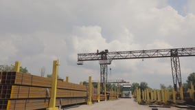 Een brugkraan laadt metaal in een vrachtwagen, laadt metaal in een pakhuis, een grote brugkraan, het mensenwerk in een metaal Een brugkraan laadt metaal in een vrachtwagen, laadt metaal in een pakhuis, een grote brugkraan, het mensenwerk in een metaal