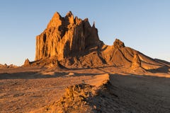 Een buigende weg leidt tot de hoge piek van Shiprock, New Mexico stock foto Een buigende weg leidt tot de hoge piek van Shiprock, New Mexico stock foto