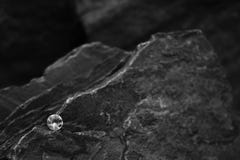 Een Close-upbeeld van Één enkel Diamond Showing de Facetten van de Gem op een Rots royalty-vrije stock foto Een Close-upbeeld van Één enkel Diamond Showing de Facetten van de Gem op een Rots royalty-vrije stock foto