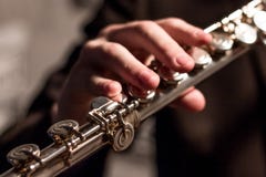 Een deel van een fluit met rechts van een mens op een fluitclose-up Ondiepe Diepte van Gebied Muzikaal thema Blaasinstrument mode stock afbeelding Een deel van een fluit met rechts van een mens op een fluitclose-up Ondiepe Diepte van Gebied Muzikaal thema Blaasinstrument mode stock afbeelding