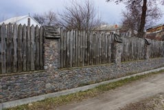 Een deel van een oude landelijke die omheining van stenen en grijze scherpe logboeken buiten in het gras wordt gemaakt stock afbeeldingen Een deel van een oude landelijke die omheining van stenen en grijze scherpe logboeken buiten in het gras wordt gemaakt stock afbeeldingen
