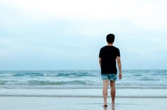 Een eenzame Aziatische mens die alleen op strand lopen royalty-vrije stock afbeelding Een eenzame Aziatische mens die alleen op strand lopen royalty-vrije stock afbeelding