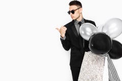 Een elegante mens in een zwart kostuum, met zakken in zijn handen, en bal royalty-vrije stock foto's Een elegante mens in een zwart kostuum, met zakken in zijn handen, en bal royalty-vrije stock foto's