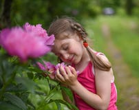 Een foto van een klein meisje die grote heldere bloemen met haar gesloten ogen ruiken royalty-vrije stock foto Een foto van een klein meisje die grote heldere bloemen met haar gesloten ogen ruiken royalty-vrije stock foto