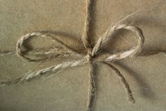 Een foto van een knoop met een boog van streng bond over kraftpapier-document op het vakje royalty-vrije stock afbeelding Een foto van een knoop met een boog van streng bond over kraftpapier-document op het vakje royalty-vrije stock afbeelding